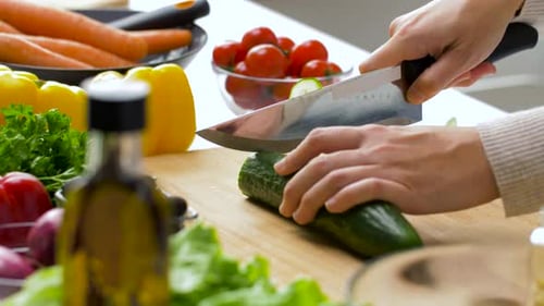 Cucumber Slicing on Wooden Board with Fresh Vegetables
