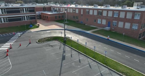 USA flag at American middle school building, exterior aerial establishing shot of public education s