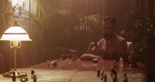 Man Filling Vials at a Table with Lab Equipment