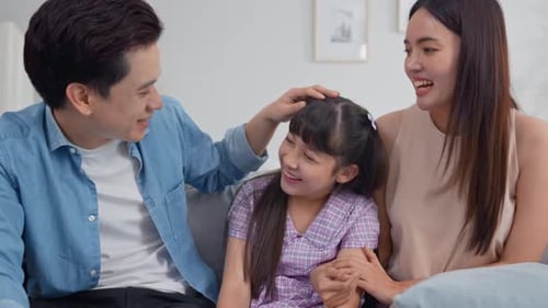 Loving Family Laughing Together on Couch at Home