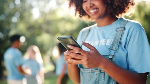 Smiling Woman Using Phone in Sunny Park