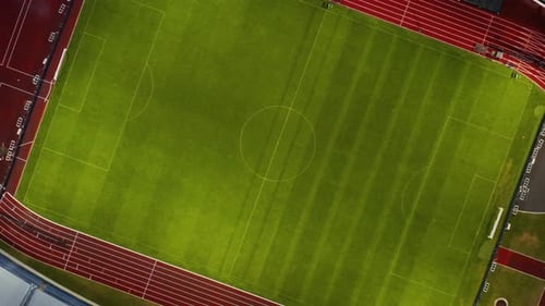 Green grass football field at night, top down