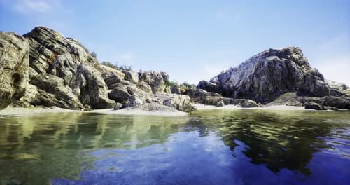 Scenic Coastal View with Rocky Formations and Clear Water Under Blue Sky