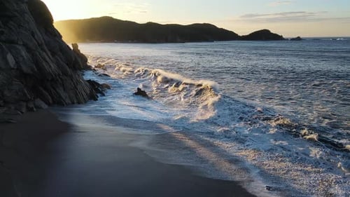 Raging Sea in the Morning at Dawn Waves Roll on the Rocky Shore Spray Soars Into the Sky