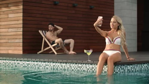 Beautiful Woman Taking Mobile Selfie in Swimming Pool. Sexy Woman Posing For