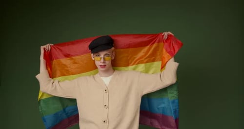 Caucasian Transgender Man with Rainbow Flag on Green Canvas