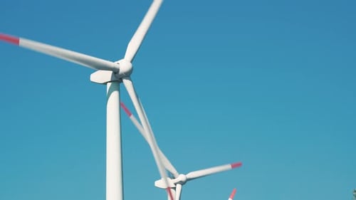 Large rotating wind turbine blades against the blue sky
