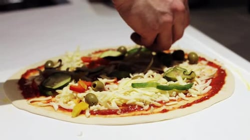 Comida, cocina italiana y concepto de cocina: cocine agregando queso rallado y