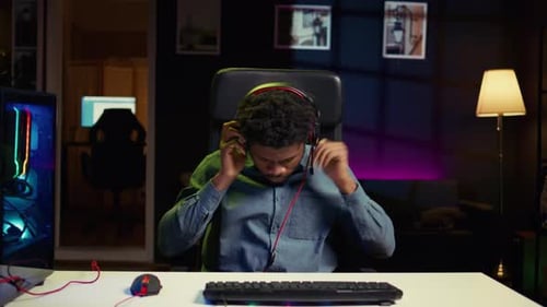 Young Adult Plays Video Games at Night