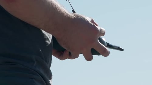 Man Controls Drone with Remote Control on Clear Day