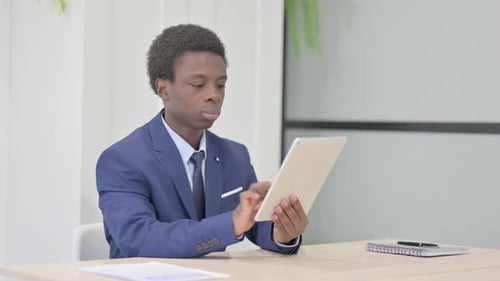 Young Adult Using Tablet in Bright Modern Office
