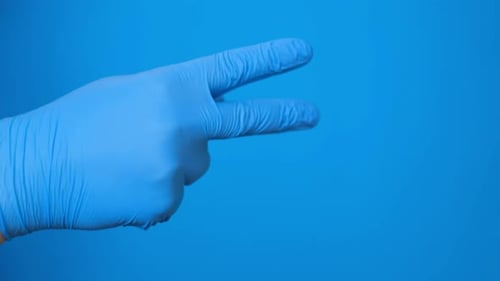 La main d'un médecin portant des gants en caoutchouc compte avec ses doigts