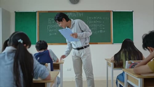 Teacher Helping Students with Math in Classroom