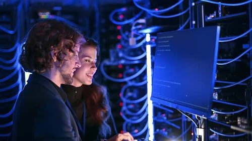 Ein Mann und eine Frau jubeln in einem Serverraum