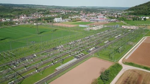 High voltage power tower in substation with transmission power lines and pylons
