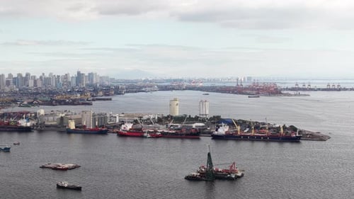 Industrial seaport with cargo ships docked at the terminal and various vessels moving across the