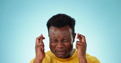 Worried Man Crossing Fingers Hopes for Good Luck