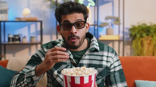 Man Eating Popcorn Watching 3D Movie at Home