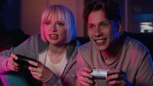 Young Adults Playing Video Games at Home at Night