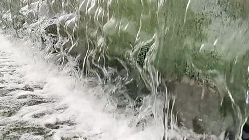 Gotas de água de close-up ou de uma fonte em uma pequena piscina na cidade. Câmera lenta