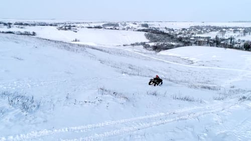 Aerial Shot of Man Driving ATV at Winter Field