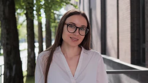 Smiling Young Woman Wearing Glasses Outdoors