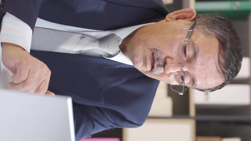 Vertical video of Businessman works focused on his work.