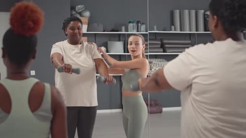 Fitness Instructor Guides Adults Through Dumbbell Exercise