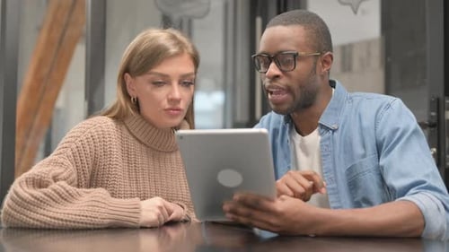 Young People Working on Tablet in Office