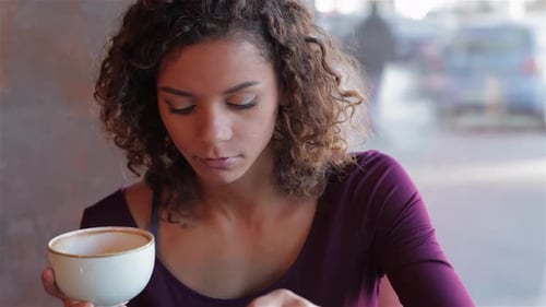 Young Woman Eating and Drinking in Urban Cafe