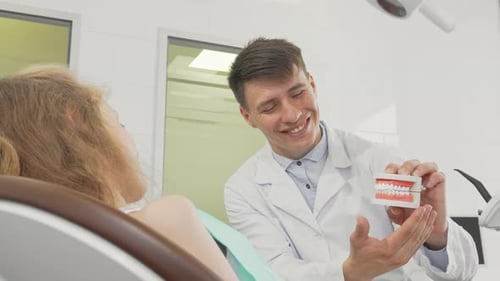 Dentist Explaining Dental Hygiene to Child Patient