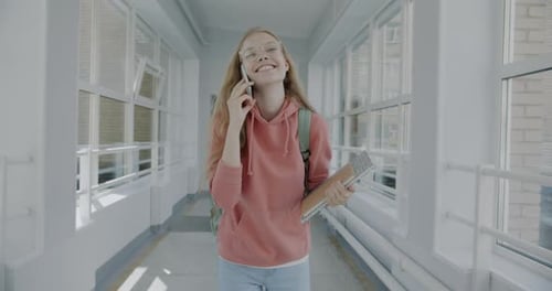 Smiling Student Talking on Phone in School Hallway