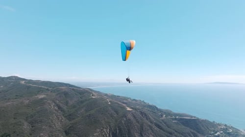 Epische Nahaufnahme von zwei Gleitschirmen, die in der Drohnenkamera winken, während sie im Himmel fliegen