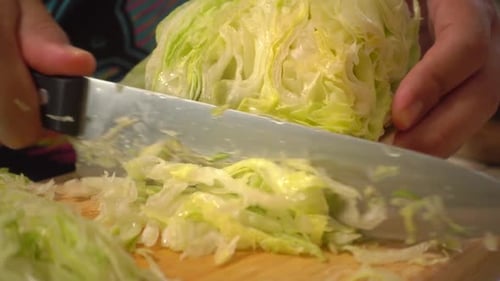 Lateral view of a lettuce shredded on a cutting board.