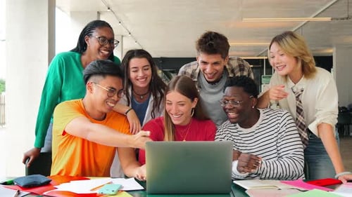 Big Group of Young Students Using a Laptop to Do the Homeworks at High School Library Teenagers