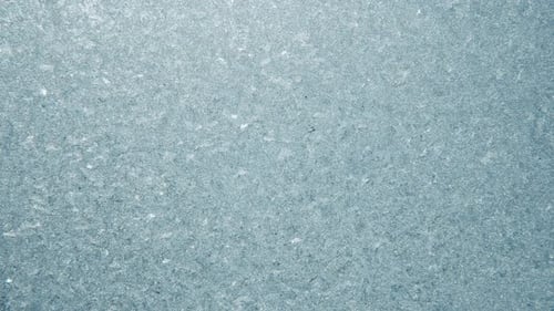 Frozen Window with Glistening Ice Crystals in Winter