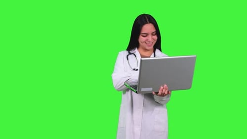 Latin Female Doctor Working on Laptop with Green Screen
