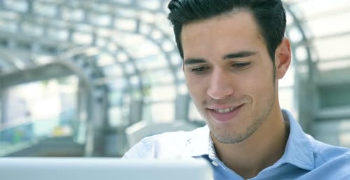 Smiling Man Using Tablet in Bright Urban Location
