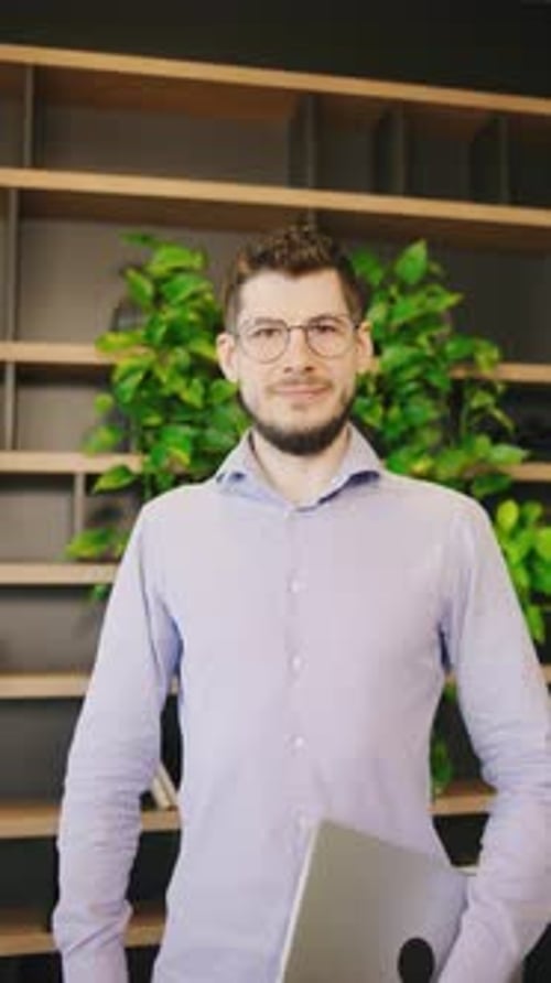 This is a Professional Portrait of a Smiling Young Man in a Modern Office Environment Perfectly