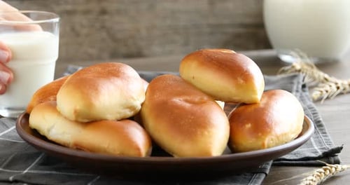 Delicious pastries on plate next to milk