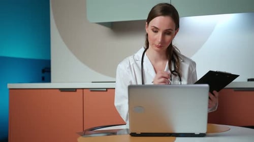 Female Doctor Telemedicine Consultation with Laptop and Clipboard