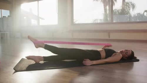 Young Woman Exercising Legs with Resistance Band
