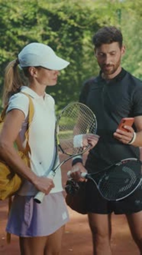 Tennis Players Reviewing Phone on the Court