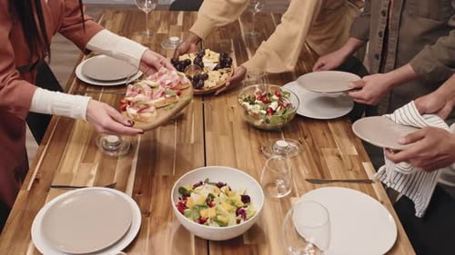 Friends Preparing a Meal Together at a Wooden Table