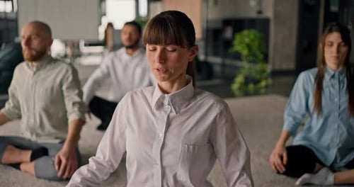 A Closeup of a Caucasian Office Worker Guiding Her Colleagues Through Relaxing Stretching Exercises