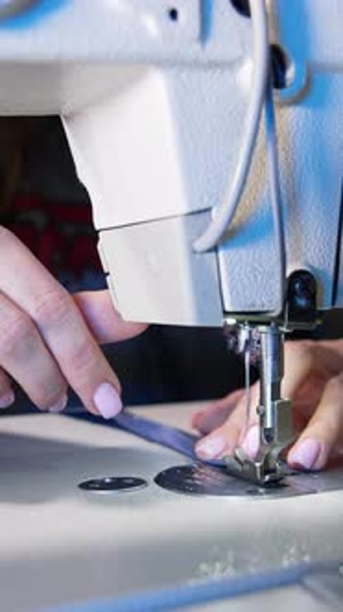 Process of sewing fabric on a sewing machine. Tailor working with sewing machine at workshop
