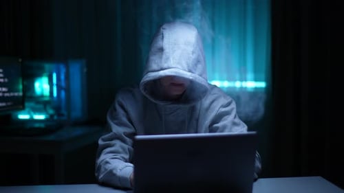 Unbekannter Hacker-Mann in Hoodie, der Elektronisch Zigaretten vapt und Online-Website hackt oder