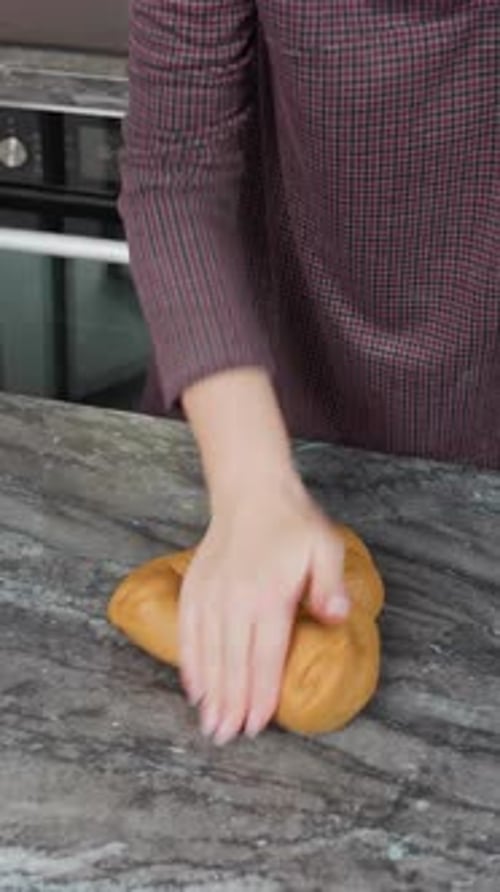 Top Down View of Woman Kneading Fresh Dough with Right Hand on Kitchen Counter