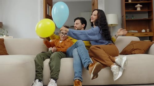 Family Throws Balloons on the Couch Together