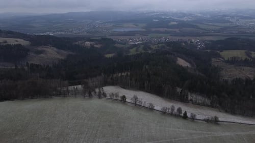 A flight over the countryside with a path leading through the trees and a view of the surrounding th